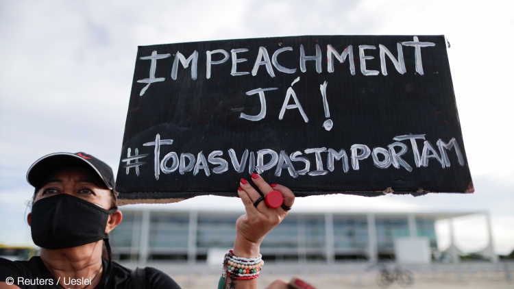 A protester holds a sign reading "Impeachment, now!" during a demonstration in Brasilia.