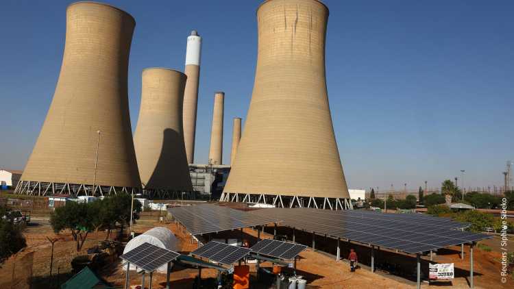 Solar panels are seen near the cooling towers of a retired coal-fired Komati Power Station, operated by Eskom, near Komati village, in the Mpumalanga province in South Africa, May 9, 2024.