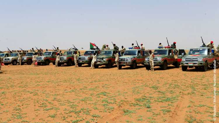 Members of Sudanʼs paramilitary Rapid Support Forces stand next to vehicles during an operation to locate and arrest Irregular migrants from Ethiopia, Sudan, and Chad who were abandoned near the Libyan border and taken to the Khartoum State border, Sudan
