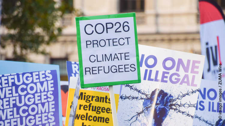A placard calling on COP26 climate change conference to protect climate refugees is seen during the Refugees Welcome rally. Demonstrators gathered in Parliament Square in support of refugees and in opposition to the Nationality and Borders Bill.