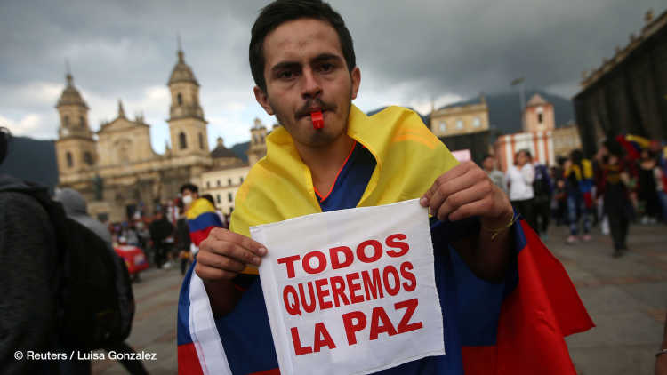 A protester holds a placard during a demonstration on Plaza de Bolivar as the national strike continues, in Bogota, Colombia 