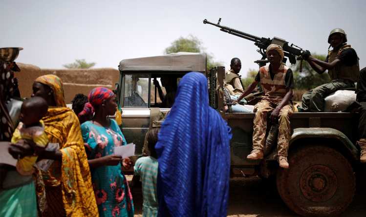 FAMa soldiers in car in front of women in Mali