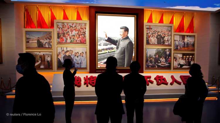 A guide talks to visitors in front of images of Chinese President Xi Jinping, at the Museum of the Communist Party of China in Beijing, China October 13, 2022