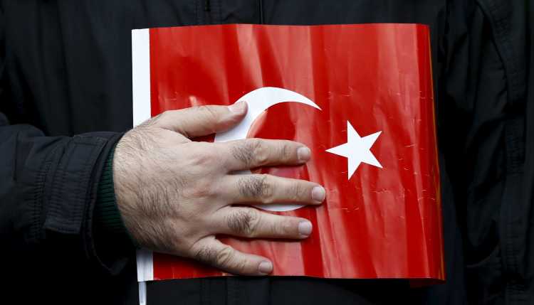A hand on a Turkish flag.